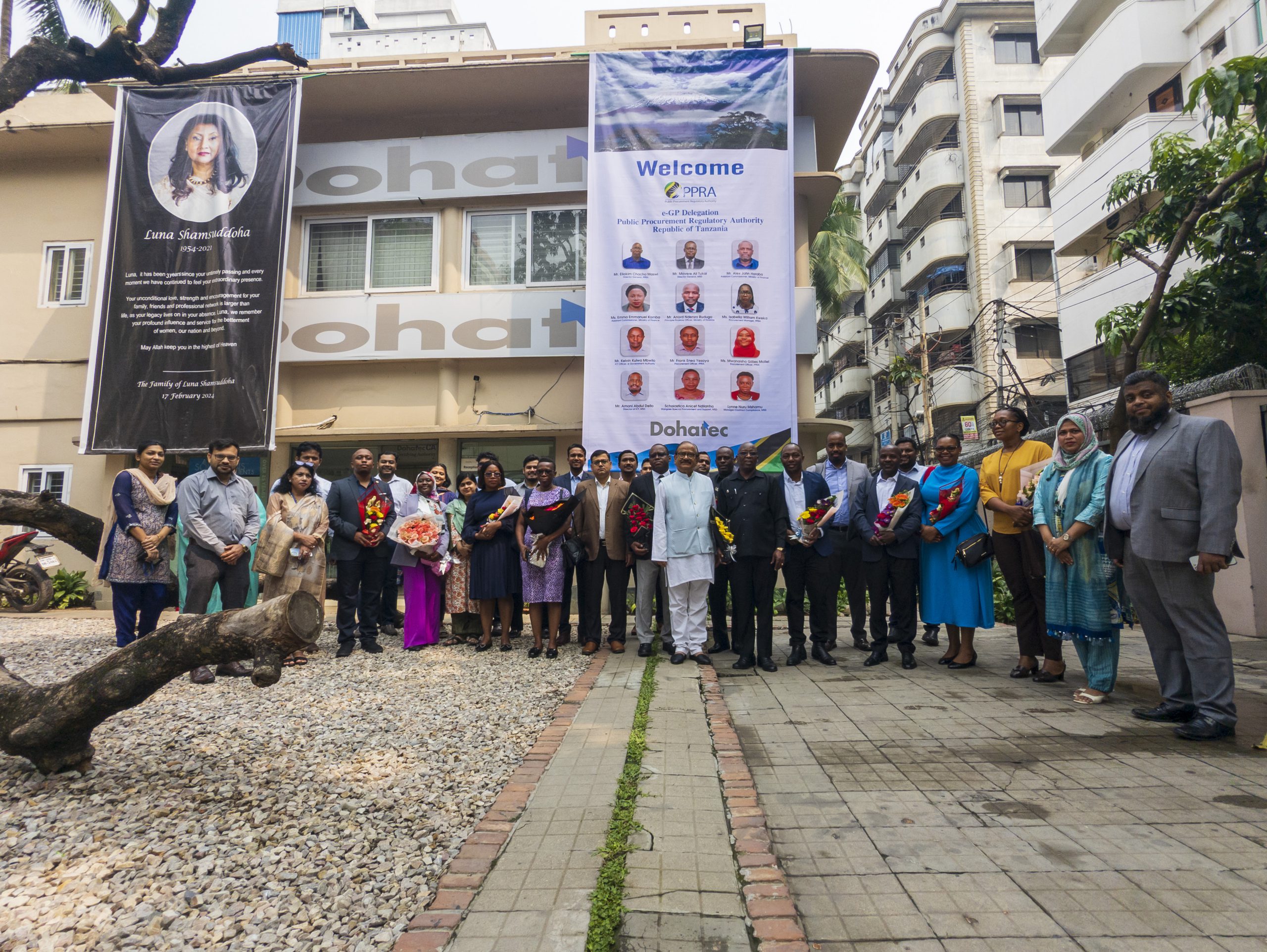 Dohatec Employees and the Tanzanian Delegates standing together in front of Dohatec HQ in Paltan